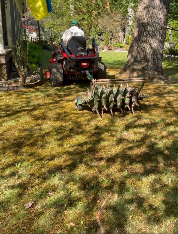 Core aeration equipment towed across a lawn in Maryland